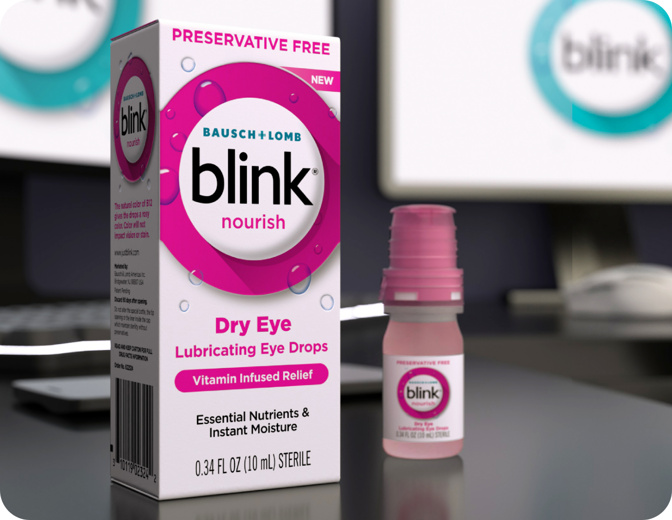 Blink Nourish Lubricating Eye Drops bottle and carton on a desk in front of a computer monitor